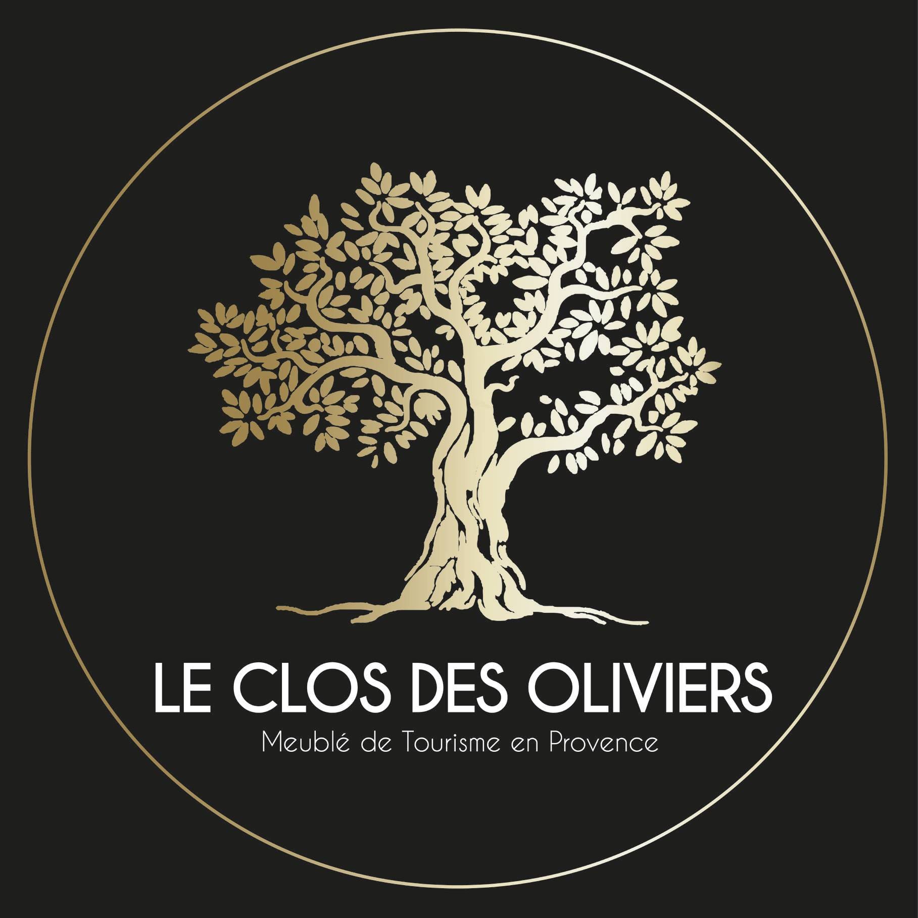Logo doré du Clos des Oliviers représentant un olivier stylisé sur fond noir, accompagné de la mention « Meublé de Tourisme en Provence ».
